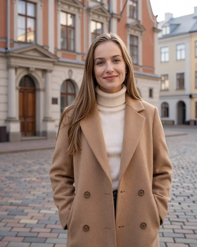Latvian woman Ieva smiling on a cobblestone street in Riga Old Town