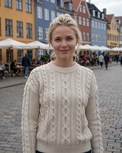 Danish woman Freja smiling on a cobblestone street in Copenhagen Nyhavn district