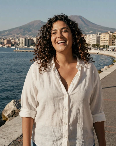 Italian woman Chiara laughing on the Naples waterfront with Mount Vesuvius behind