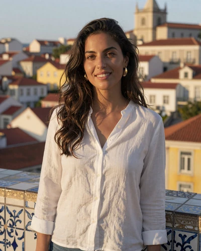Portuguese woman Inês smiling at a Lisbon viewpoint overlooking Alfama rooftops