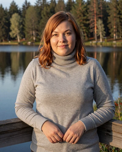 Finnish woman Iida by a calm lake near Jyväskylä at golden hour