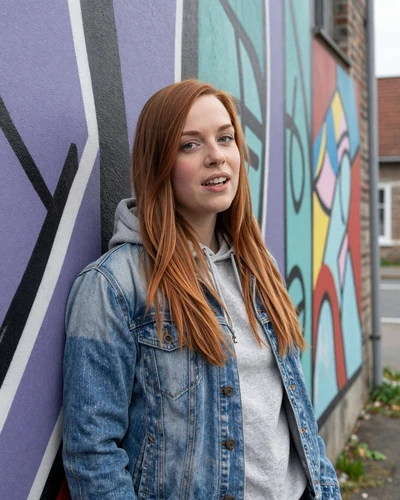 Belgian woman Eva posing near colorful street art mural in Charleroi